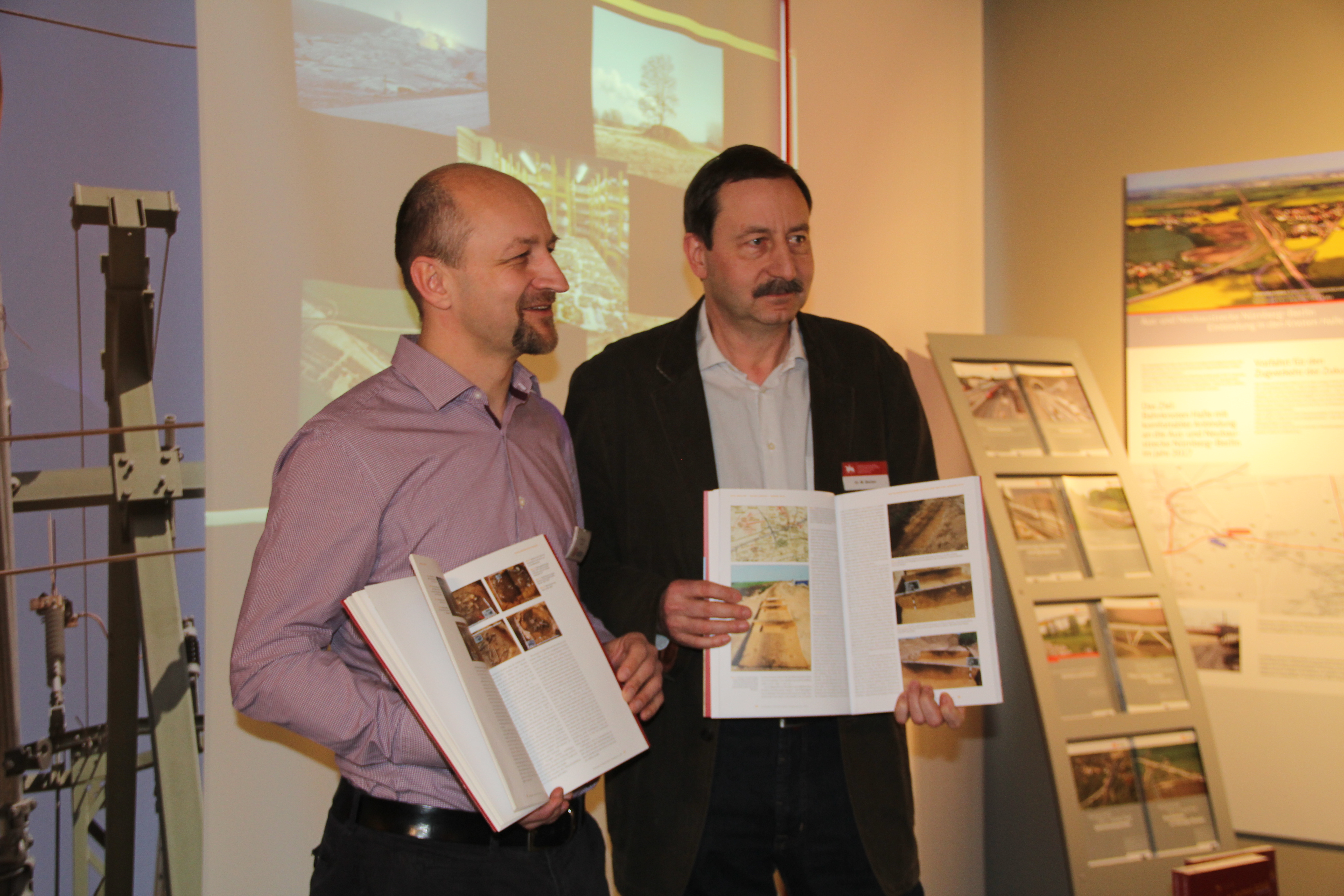 Reiner Selig (l.) und Dr. Matthias Becker präsentieren die beiden Bände – Neue Gleise auf alten Wegen II. Jüdendorf bis Gröbers. Archäologie in Sachsen-Anhalt Sonderband 26 –
